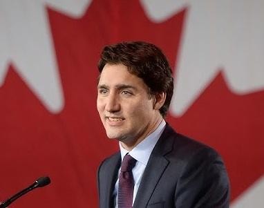 Justin Trudeau w interakcji z publicznością podczas wydarzenia politycznego, uśmiechnięty i przystępny, symbolizujący jego związek z obywatelami.