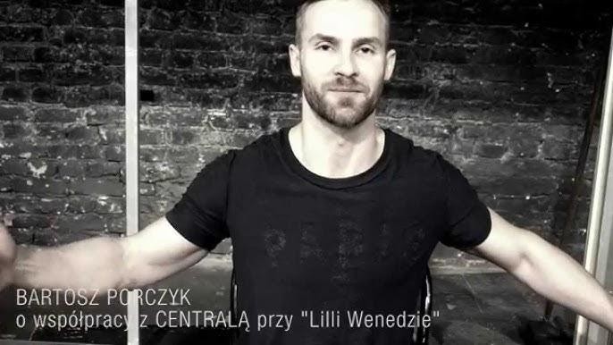 Bartosz Porczyk na scenie teatralnej, w trakcie dynamicznego występu, z intensywną ekspresją, podkreślającą jego silną obecność sceniczną.