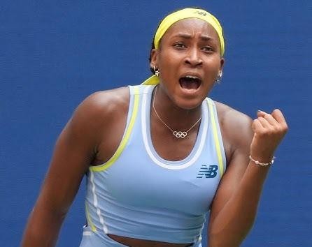 Coco Gauff celebrująca punkt na korcie tenisowym, z zaciśniętą pięścią i zdeterminowanym wyrazem twarzy.