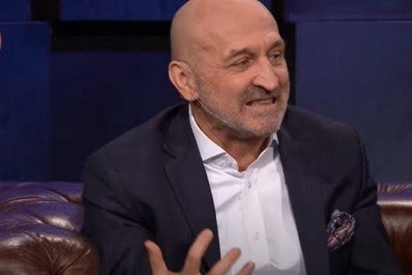 Kazimierz Marcinkiewicz podczas wystąpienia publicznego lub negocjacji, symbolizujący jego karierę polityczną.