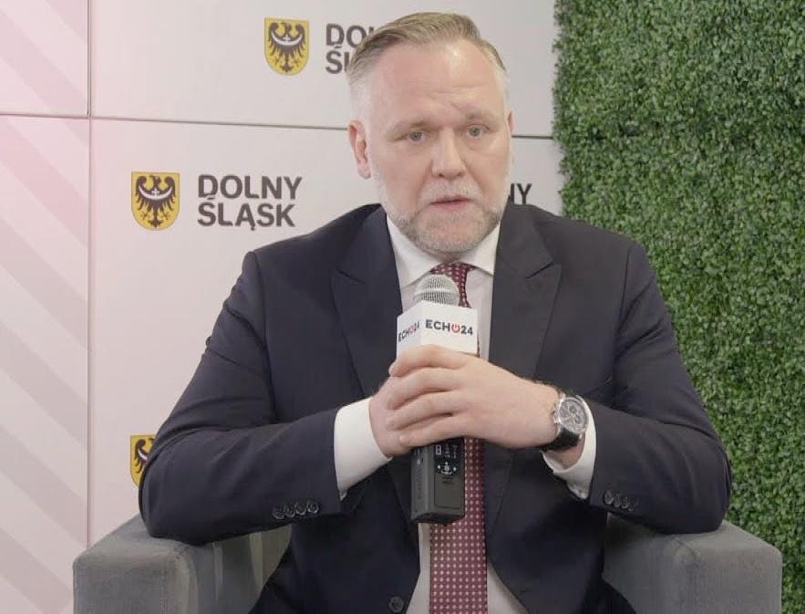 Dawid Jackiewicz przemawiający na konferencji politycznej, gestykulujący z przekonaniem.