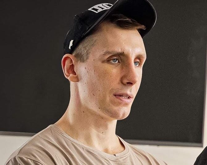 Owca WK (Michał Owczarzak) przeglądający swój profil na Instagramie, ukazujący muskularną sylwetkę w tle siłowni.