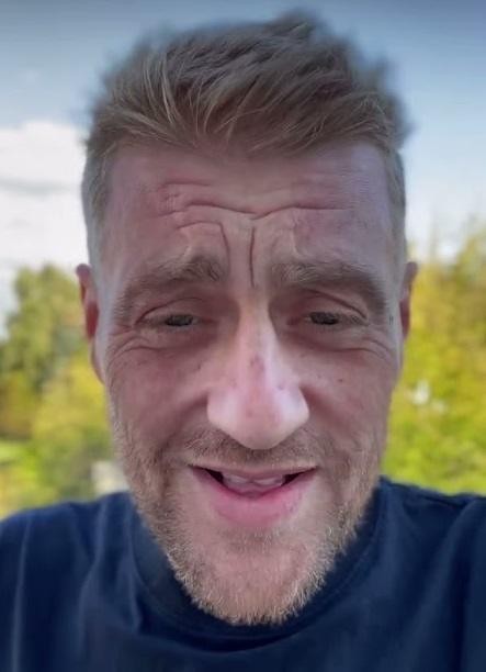 Tomasz Jakubiak z uśmiechem, trzymający świeży składnik, symbolizujący jego pasję do lokalnej kuchni.