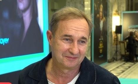Marek Kalita na scenie podczas występu, w dynamicznej pozie, z teatralnym oświetleniem, oddający emocje swojej roli.