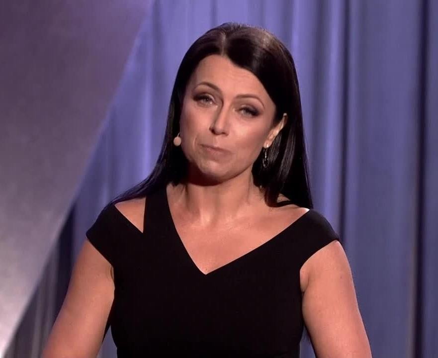 Adrianna Borek na scenie kabaretowej, podczas występu, z ekspresyjną mimiką i gestykulacją, oddająca energię i humor.
