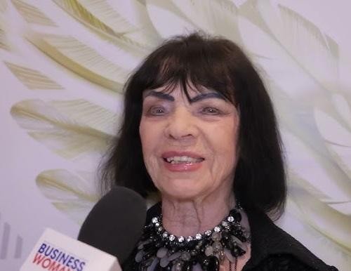 Sława Przybylska na scenie podczas występu, z pasją śpiewająca do mikrofonu, w otoczeniu ciepłych świateł.