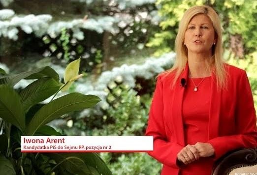 Iwona Arent przemawiająca z mównicy sejmowej lub podczas wiecu politycznego, gestykulująca z zaangażowaniem.